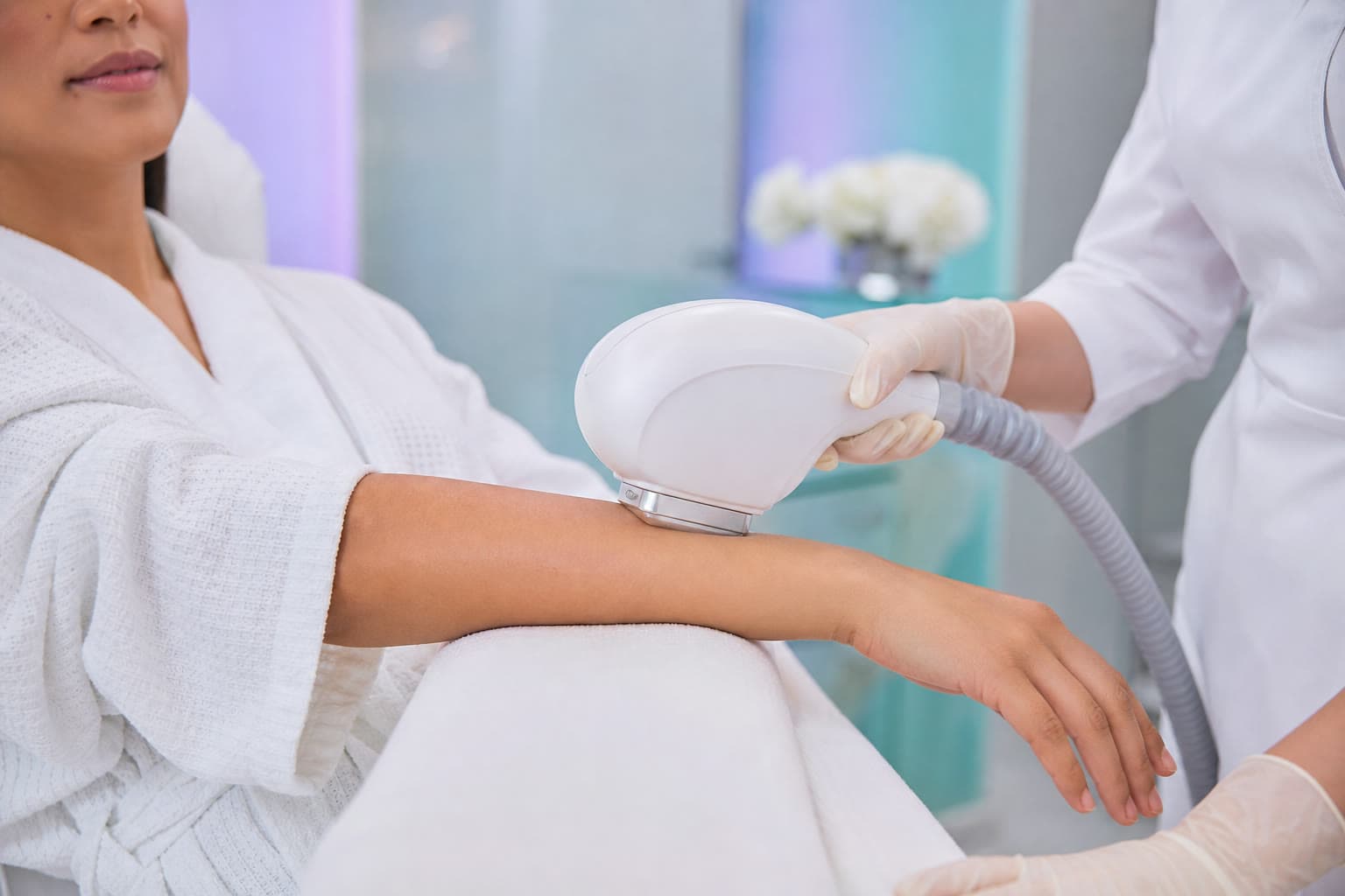 Smooth body-contouring applicator gliding along the forearm in a clinic setting