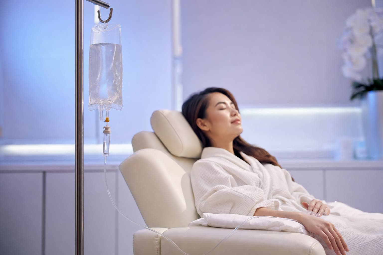 Clear IV vitamin drip beside a patient resting in a calm wellness recliner